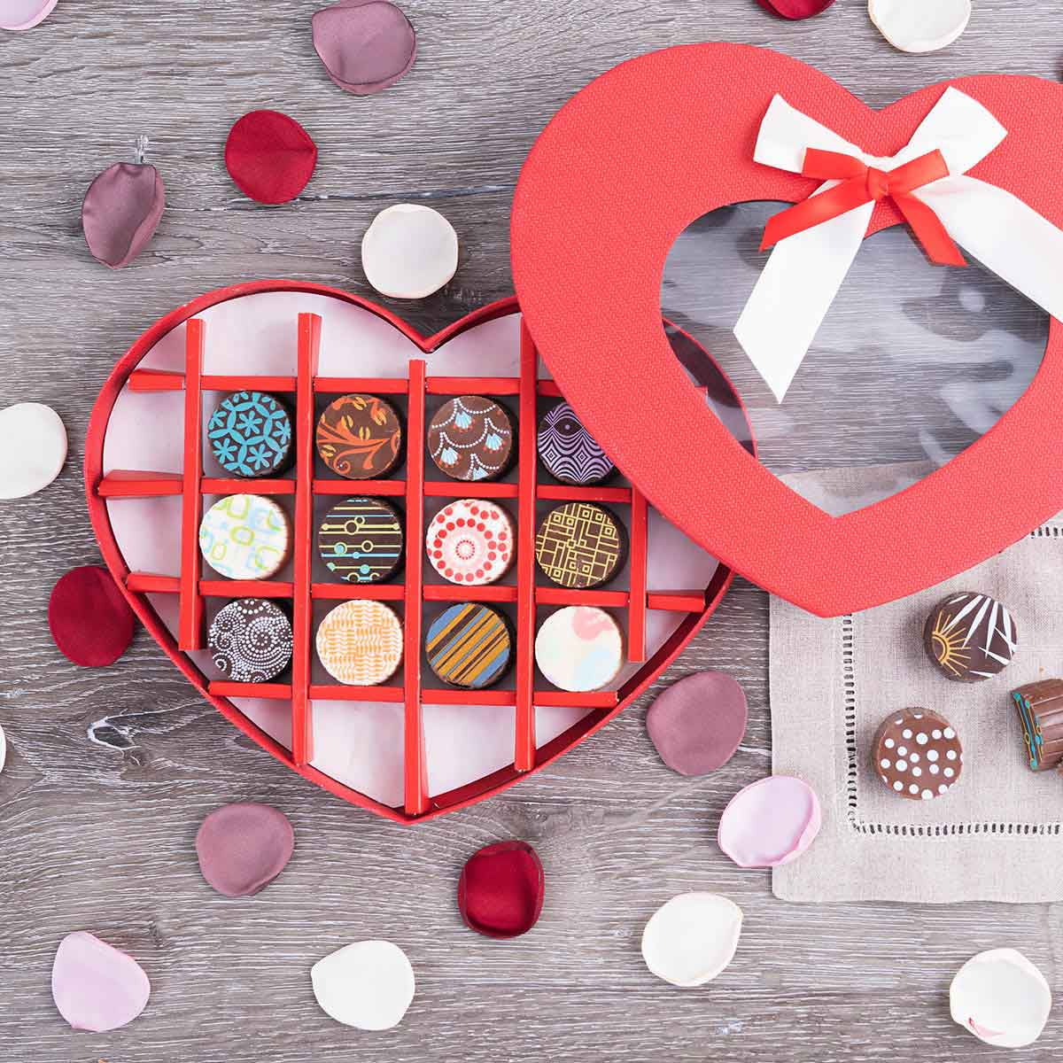 Give a gift you know they’ll love with our Cross My Heart Deluxe Valentine’s Chocolate Truffles Gift Box! Beautifully designed box of 12 hand-dipped, Belgian truffles is sure to make recipients smile. Each truffle features a decorative design and filled with an assortment of flavors including cupcake, cookie dough, rum and more!